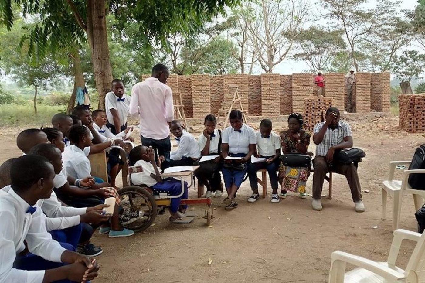 Community monitors meet in front of new toilet blocks