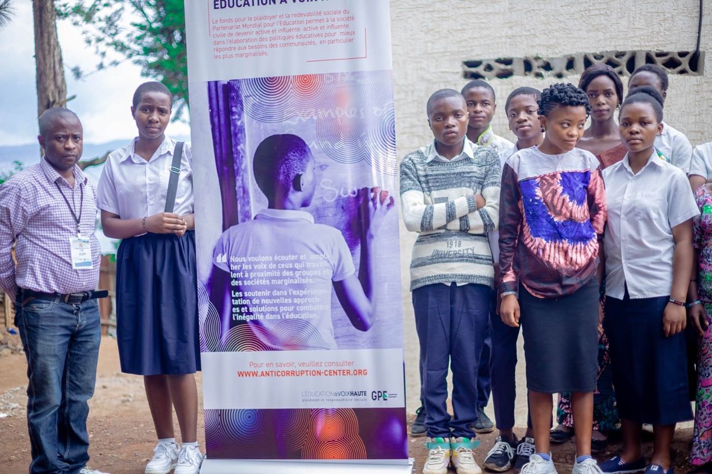 Integrity Club members and a teacher standing next to a CERC banner