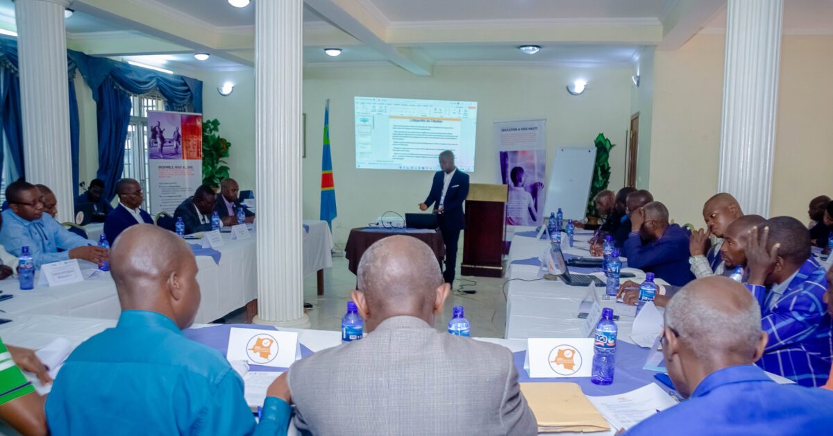 Senior education officials seated around tables at the consultation workshop in Bukavu